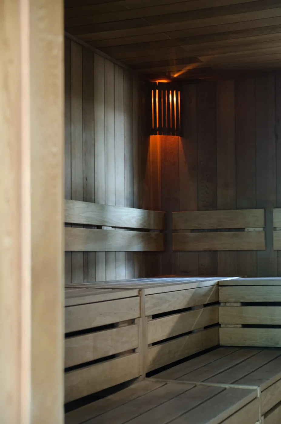 Houten banken en warme verlichting in de sauna van De Meerval