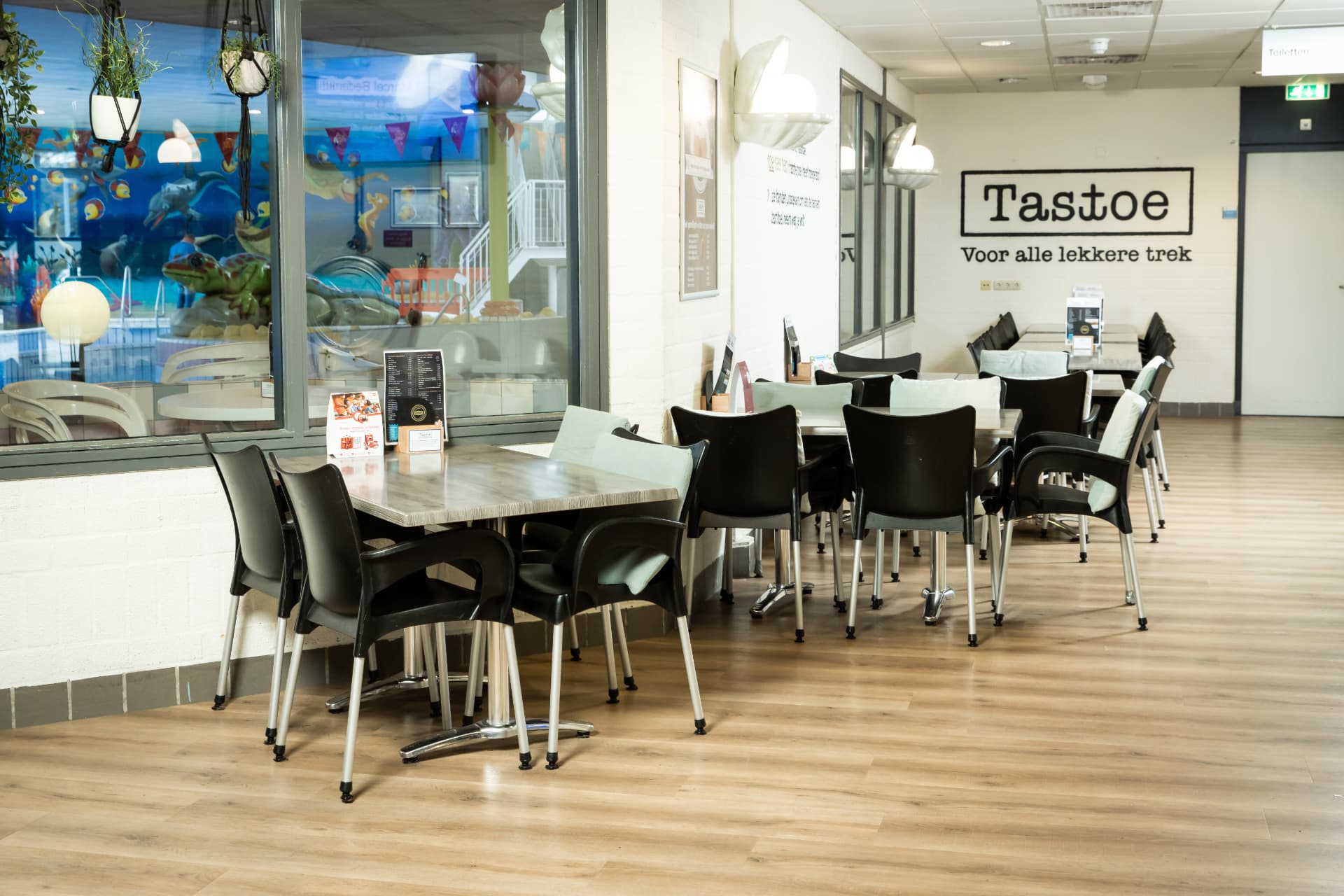 Zithoek van restaurant Tasttoe met uitzicht op het recreatiebad