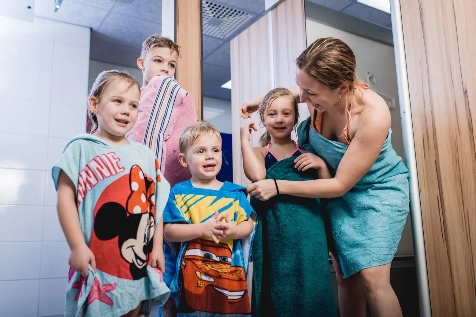 Kinderen met kleurige badhanddoeken in de kleedruimtes van De Meerval