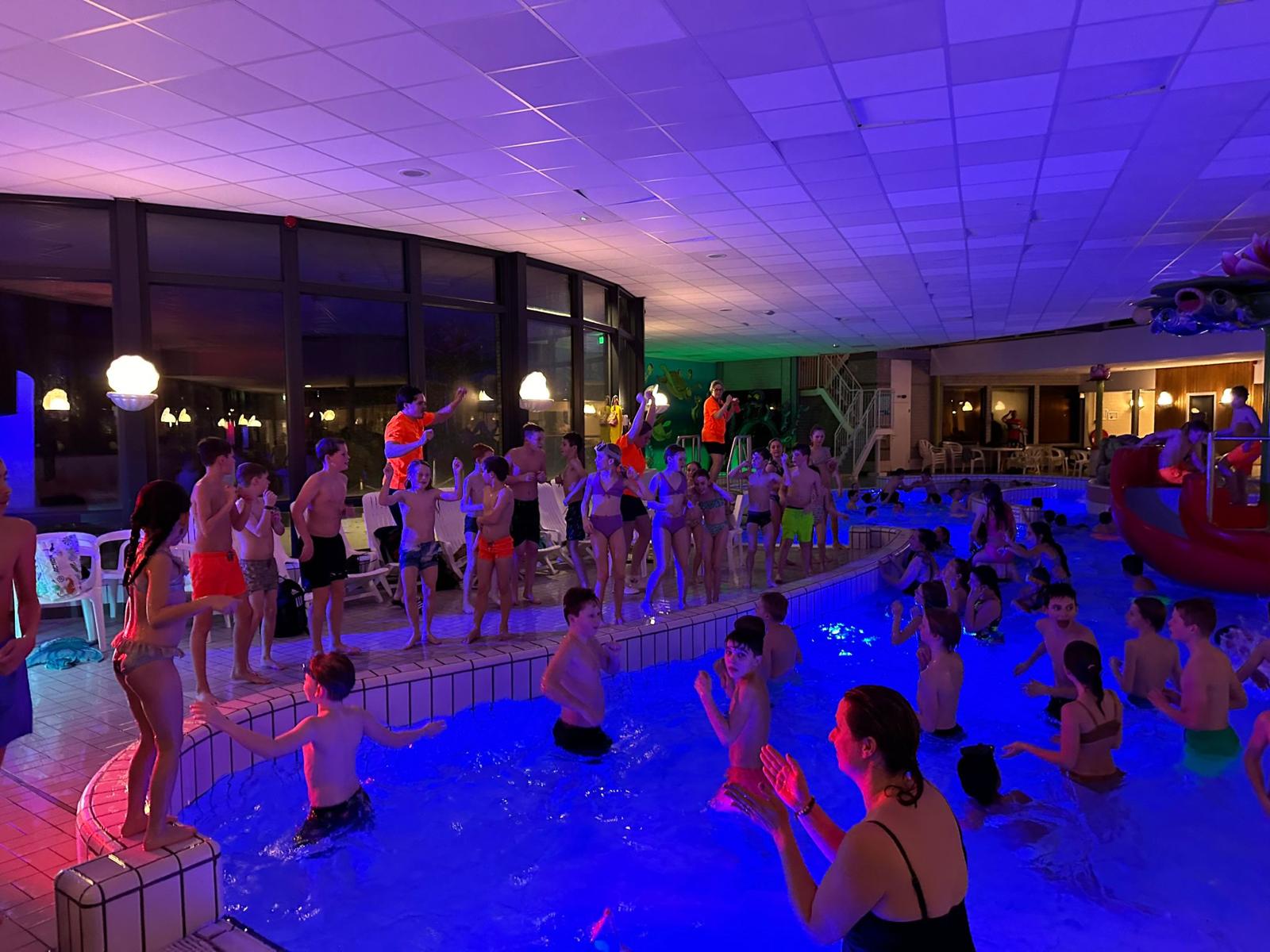Kinderen zwemmen tijdens een discoavond