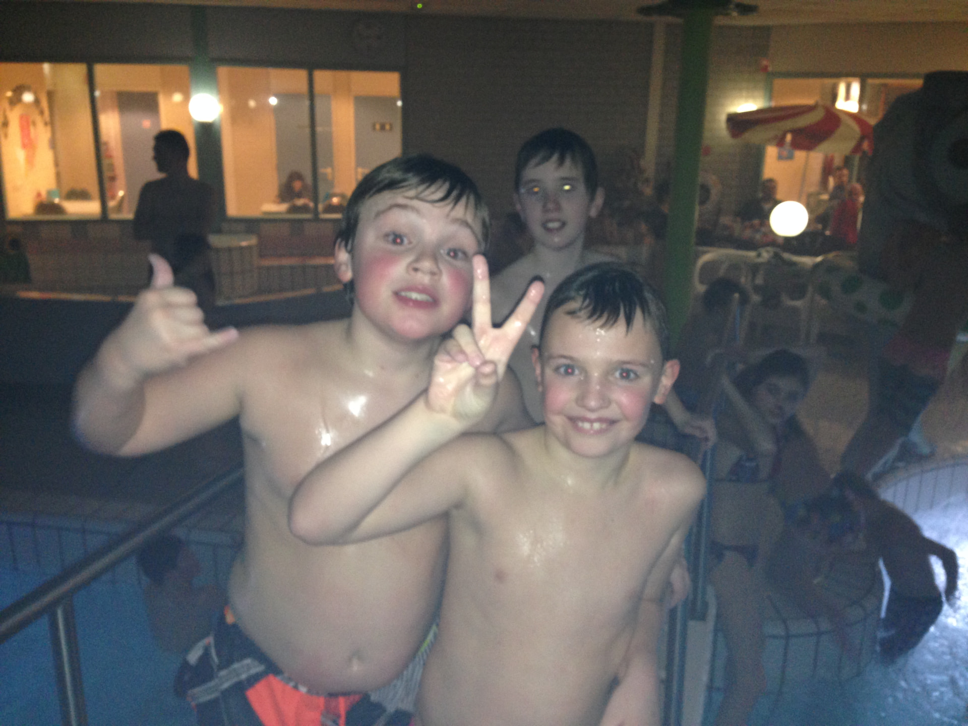 Twee lachende kinderen bij het zwembad tijdens het Discozwemmen