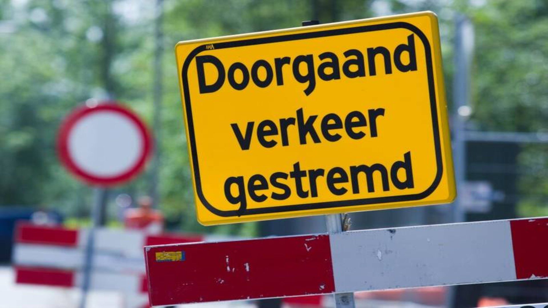Geel verkeersbord met de tekst Doorgaand verkeer gestremd bij wegwerkzaamheden